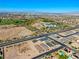 Aerial view showcasing neighborhood featuring green spaces, roads, houses, and city background at 1005 Warsaw Ave, Henderson, NV 89015