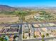 Aerial view of neighborhood featuring green spaces, roads, houses, and a mountain background at 1005 Warsaw Ave, Henderson, NV 89015