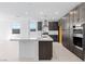 Spacious kitchen showcasing dark wood cabinets, a white center island, and stainless steel appliances at 1005 Warsaw Ave, Henderson, NV 89015