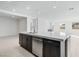 Open kitchen with stainless steel dishwasher and faucet on an island with view of an open living area at 1005 Warsaw Ave, Henderson, NV 89015