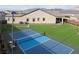 A spacious backyard featuring a full sport court, an artificial lawn, and desert landscaping around the home at 10420 Luella Ct, Las Vegas, NV 89143