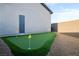 Backyard putting green area featuring artificial turf, flags, decorative rock and a block wall at 10420 Luella Ct, Las Vegas, NV 89143