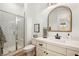 Modern bathroom with a glass walk-in shower, and a white vanity with quartz countertops and dark hardware at 10420 Luella Ct, Las Vegas, NV 89143