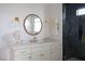 Modern bathroom vanity with white marble countertop, gold fixtures, and stylish wavy mirror at 10420 Luella Ct, Las Vegas, NV 89143