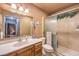 A well-lit bathroom features a vanity with ample counter space and a shower enclosed with glass doors at 10615 Rancho Destino Rd, Las Vegas, NV 89183