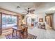 Bright dining room with a ceiling fan, tile floors, and view of the greenery outside, perfect for Gathering meals at 10615 Rancho Destino Rd, Las Vegas, NV 89183