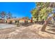 Spacious single-story home with a side patio and mature trees providing shade and enhancing its curb appeal at 10615 Rancho Destino Rd, Las Vegas, NV 89183
