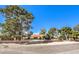 Inviting single-story residence with lush, mature trees and a brick-lined fence offering a serene atmosphere at 10615 Rancho Destino Rd, Las Vegas, NV 89183