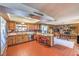 Open kitchen with tiled floors, wooden cabinets, and a breakfast bar overlooking the living area at 10615 Rancho Destino Rd, Las Vegas, NV 89183