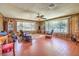 Spacious living room with wood-paneled walls, tile floors, large windows, and comfortable seating arrangements at 10615 Rancho Destino Rd, Las Vegas, NV 89183