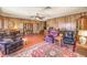 A large living area with wood paneled walls and tile flooring is furnished with comfortable seating and ample space at 10615 Rancho Destino Rd, Las Vegas, NV 89183