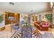 Spacious living room with tiled floors, decorative plants, a Zebra-print rug, and a vintage leather sofa at 10615 Rancho Destino Rd, Las Vegas, NV 89183