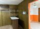 Basement bar area with shelving and storage, adjacent to a room with bold orange and white walls at 1201 Madison Ave, Las Vegas, NV 89106