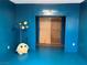 Cozy bedroom with unique blue walls, a colorful lamp, and a fun plush toy at 1201 Madison Ave, Las Vegas, NV 89106