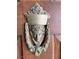 Vintage door knocker with a decorative face on a wooden door at 1201 Madison Ave, Las Vegas, NV 89106