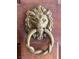Detailed lion head door knocker on a rustic wooden door at 1201 Madison Ave, Las Vegas, NV 89106
