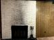 Classic white brick fireplace with black hearth and wood-paneled wall, adding warmth and charm to the living space at 1201 Madison Ave, Las Vegas, NV 89106