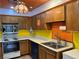 Kitchen boasting wood cabinets, stainless steel sink, and appliances, illuminated by a retro hanging light fixture at 1201 Madison Ave, Las Vegas, NV 89106
