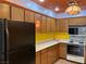 Cozy kitchen featuring wooden cabinets, yellow accents, and appliances including a refrigerator and microwave at 1201 Madison Ave, Las Vegas, NV 89106