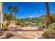 Beautifully landscaped backyard featuring desert landscaping, a patio and wrought iron fencing offering views of the community at 1363 Rolling Sunset St, Henderson, NV 89052
