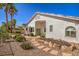 Well-maintained backyard featuring desert landscaping with a rock path and mature trees at 1363 Rolling Sunset St, Henderson, NV 89052