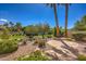 Beautiful backyard with desert landscaping, mature trees, a flagstone patio, and wrought iron fence at 1363 Rolling Sunset St, Henderson, NV 89052