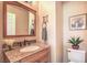 Stylish bathroom featuring a granite countertop vanity, framed mirror, and neutral color scheme at 1363 Rolling Sunset St, Henderson, NV 89052
