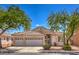 Charming home featuring a three-car garage, desert landscaping, and a tile roof in a lush setting with mature trees at 1363 Rolling Sunset St, Henderson, NV 89052