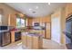 Kitchen with center island, wooden cabinets, and modern appliances at 1363 Rolling Sunset St, Henderson, NV 89052