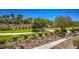 Manicured landscaping featuring desert plants, paved paths, and lush green spaces within the community at 1363 Rolling Sunset St, Henderson, NV 89052
