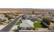A home's backyard is highlighted in this aerial shot, showcasing a lush lawn, mature trees, and neighboring homes in the distance at 1395 Logandale Dr, Logandale, NV 89021