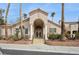 Stucco building with arched entryway, white columns, and professional landscaping featuring palm trees at 1851 Hillpointe Rd # 2412, Henderson, NV 89074