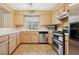 Well-lit kitchen featuring stainless steel appliances, light wood cabinets and tiled floor at 1851 Hillpointe Rd # 2412, Henderson, NV 89074