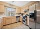 Well-lit kitchen features stainless appliances, tile flooring, and warm wood cabinets at 1851 Hillpointe Rd # 2412, Henderson, NV 89074