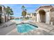 Community pool area with a hot tub, lounge chairs and palm trees at 1851 Hillpointe Rd # 2412, Henderson, NV 89074