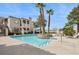 Community pool with blue water, tanning chairs, palm trees, and landscaped grounds at 1851 Hillpointe Rd # 2412, Henderson, NV 89074