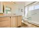 Bright bathroom with a single sink vanity, tiled countertop, and a walk-in shower with glass doors at 2201 Rosanna St, Las Vegas, NV 89117
