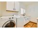 Updated laundry room with white cabinets, modern appliances, and stone-look flooring at 2201 Rosanna St, Las Vegas, NV 89117