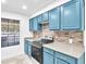 Close up view of the kitchen with modern appliances, backsplash, and blue cabinetry at 2606 S Durango Dr # 287, Las Vegas, NV 89117