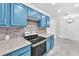 Bright kitchen features blue cabinets, stainless steel oven, tile backsplash and granite countertops at 2606 S Durango Dr # 287, Las Vegas, NV 89117