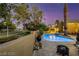 Beautiful backyard oasis featuring a pool, hot tub, and serene desert landscaping with mature trees at 3024 Half Shell Way, Las Vegas, NV 89128