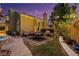 Cozy backyard with a built-in outdoor kitchen, seating area, and a hot tub under string lights at 3024 Half Shell Way, Las Vegas, NV 89128