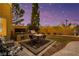 Cozy backyard featuring an outdoor kitchen, dining area, and charming string lights at 3024 Half Shell Way, Las Vegas, NV 89128