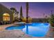 Luxurious backyard with a sparkling pool, integrated hot tub, and lush desert landscaping at 3024 Half Shell Way, Las Vegas, NV 89128