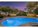 Sparkling in-ground pool surrounded by lush landscaping and a decorative retaining wall at 3024 Half Shell Way, Las Vegas, NV 89128