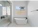 Bright bathroom featuring a soaking tub, large window, and frameless shower at 311 S Lisbon St, Henderson, NV 89015