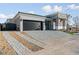 Attractive home featuring stone accents, a dark garage door, and a paved driveway at 311 S Lisbon St, Henderson, NV 89015