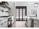 Kitchen featuring stainless steel appliances, a stone accent wall and access to the outdoor space at 311 S Lisbon St, Henderson, NV 89015