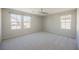 Spacious bedroom featuring neutral walls, carpet, ceiling fan, and an abundance of natural light from three windows at 3158 Teaderman Walk, Henderson, NV 89044