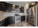 Stylish kitchen with stainless steel appliances, dark cabinets, and quartz countertops at 3158 Teaderman Walk, Henderson, NV 89044